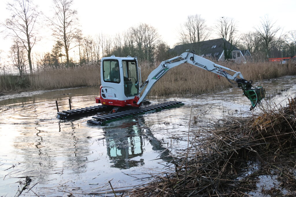 Natuurherstel en Waterbouw, Rental Referentie, Zicht: Zijaanzicht WK20 NG-A werkzaam in vijver, maaien riet in vijver