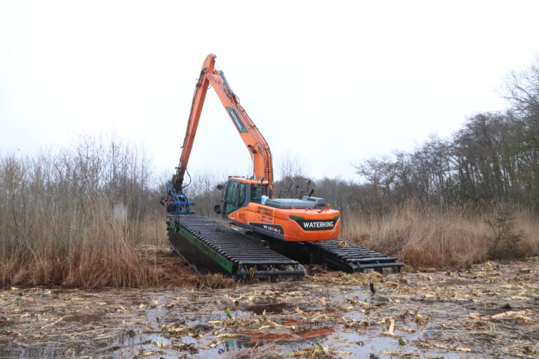 Natuurherstel en Waterbouw, Rental Referentie, Zicht: Achterzijde WK220 NG-5 uit water rijdend met frees aan giek voor natuurherstelproject
