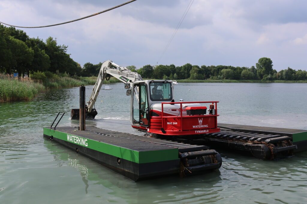WK95 NG-A incl. zijpontons aanwezig op kabelwaterskibaan Braamt voor onderhoudswerkzaamheden - Achteraanzicht van de machine op het water